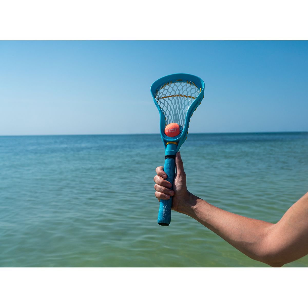 Zestaw do lacrosse dla dzieci z niebieskim kijem i pomarańczową piłką nad wodą