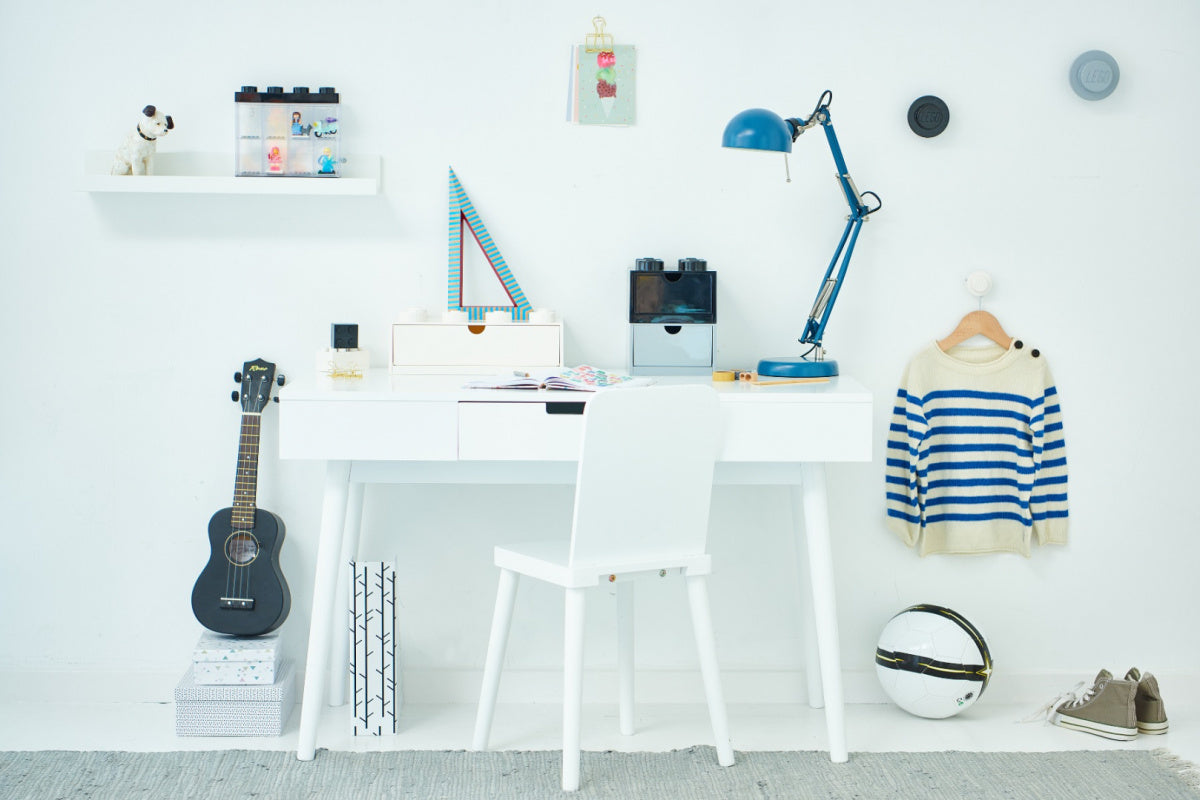 Nowoczesne białe mieszkanie z biurkiem, lampką i wieszakami LEGO na ścianę od BV JACOB COMPANY