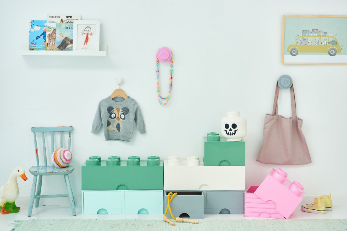 Wieszaki LEGO jasnoniebieski różowy biały na ścianie w pokoju dziecięcym z zabawkami i meblami