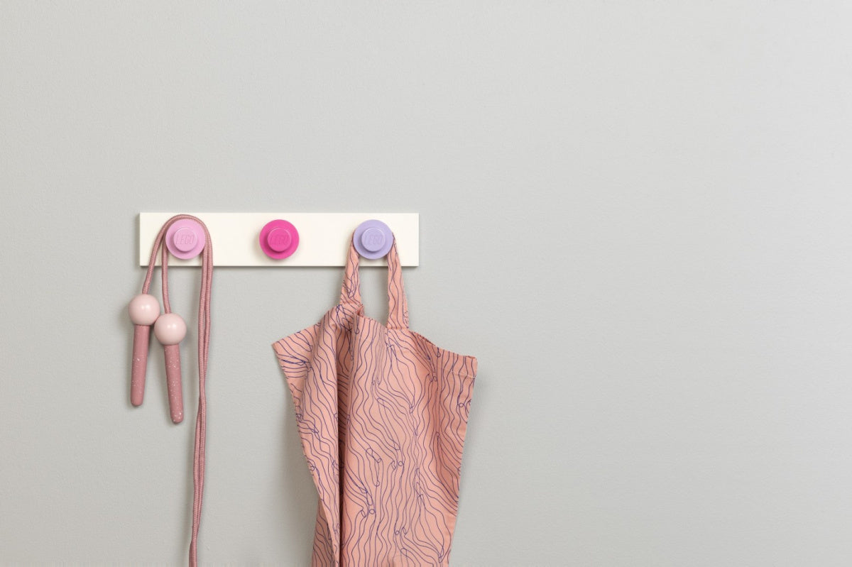 Wieszak LEGO na ścianę BV JACOB COMPANY z trzema różowymi haczykami i zawieszoną różową torbą