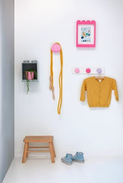 Wieszak LEGO na ścianę różowy zamocowany na białej ścianie w pokoju dziecięcym