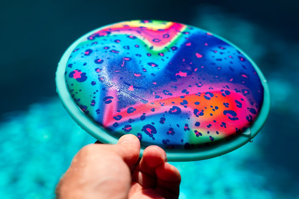 Kolorowe frisbee wodne dla dzieci trzymane nad wodą gotowe do rzutu