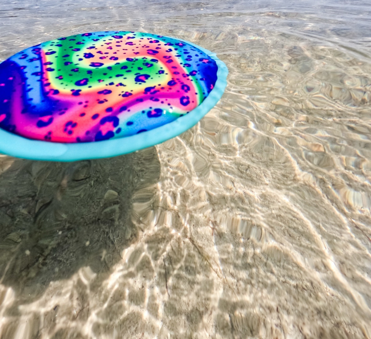 Kolorowe frisbee wodne dla dzieci unoszące się na przezroczystej wodzie plażowej