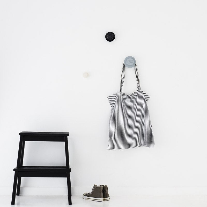 Minimalistyczne wieszaki LEGO na ścianę firmy BV JACOB COMPANY z torbą na paskach i czarną drabinką