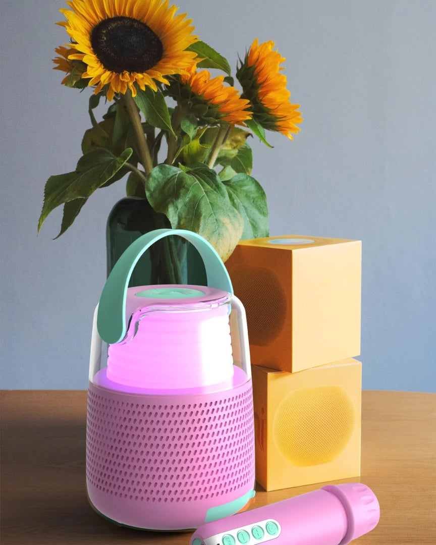 Różowy zestaw do karaoke różowy firmy MOB z mikrofonem i głośnikiem na drewnianym stole