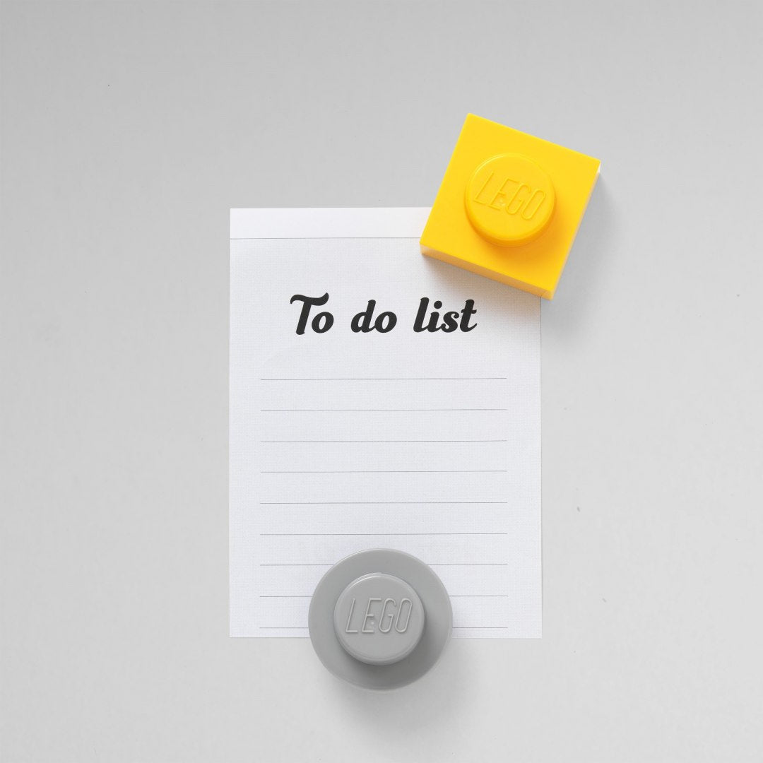 magnesy LEGO czerwone i szare na lodówce trzymające listę zadań To do list