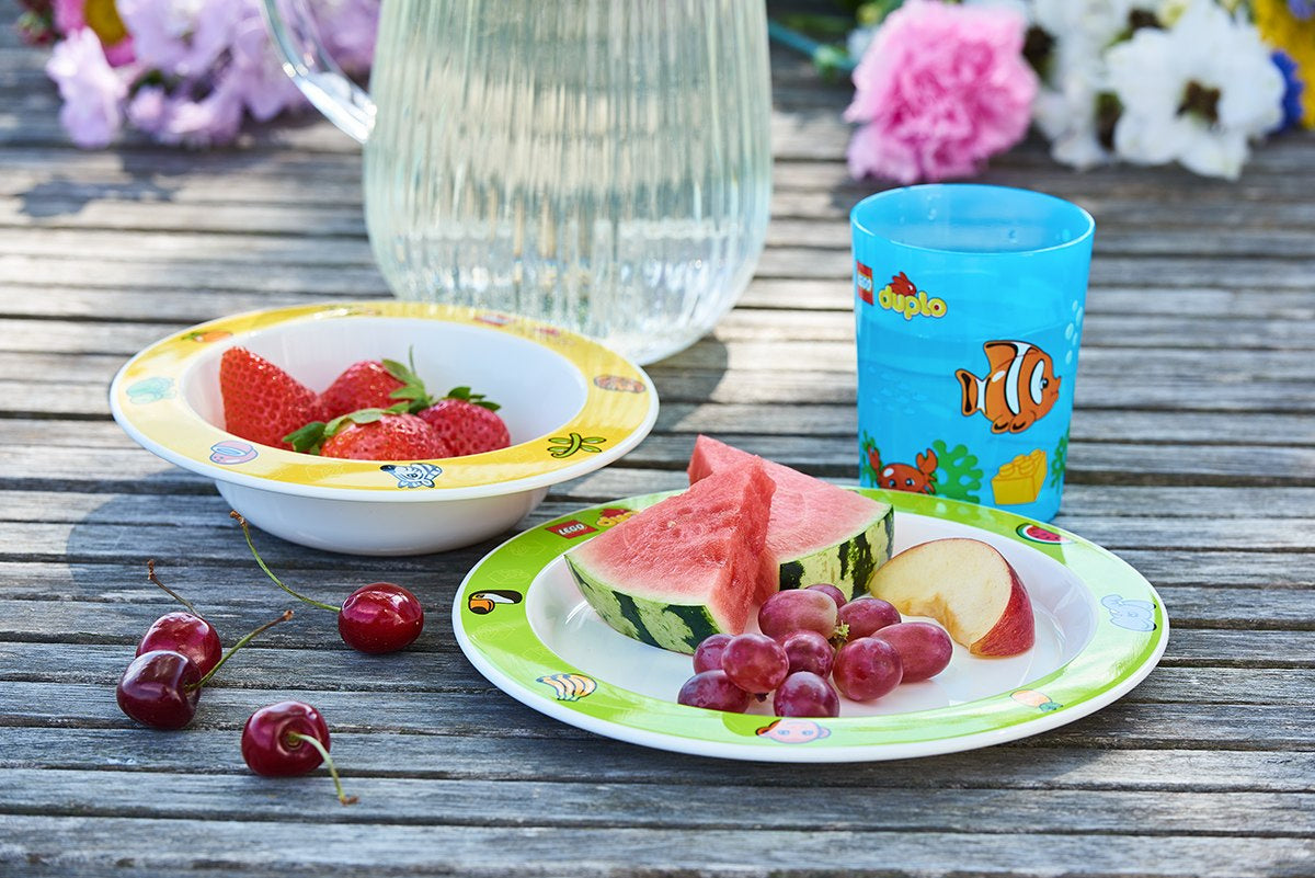 Zestaw naczyń LEGO Duplo z kolorowym talerzem, miseczką i kubkiem na drewnianym stole