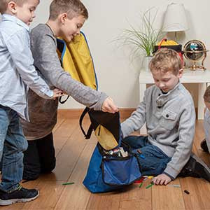 Dzieci bawiące się zestawem pojemników LEGO z matą na podłodze w pokoju