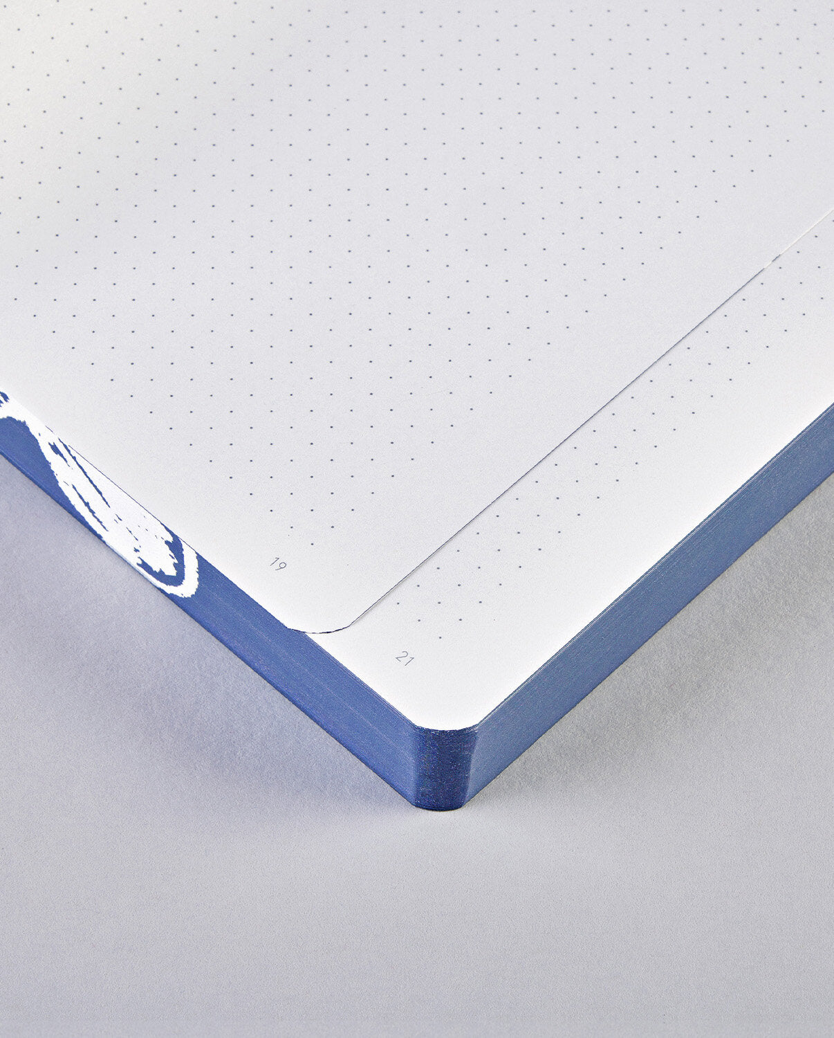 Notatnik z chmurami BV JACOB COMPANY z kropkowanymi stronami i niebieską okładką narożnik