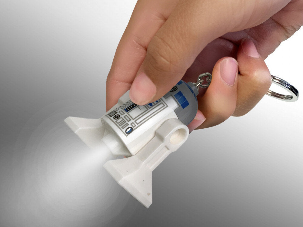 Brelok z latarką LEGO Star Wars R2D2 świecący białym światłem trzymany w ręce