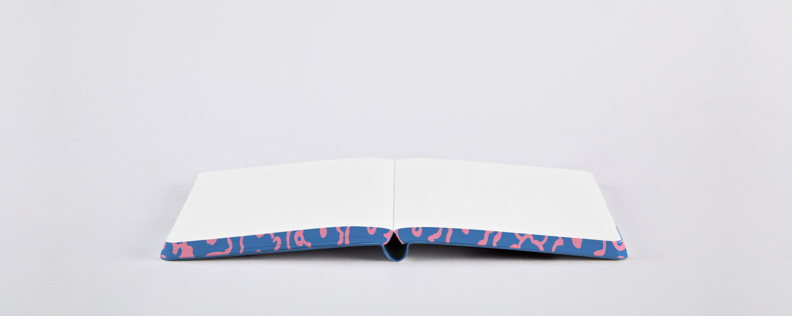 Otwarty notatnik kwiatowy z białymi stronami i kolorową okładką z kwiatowym wzorem