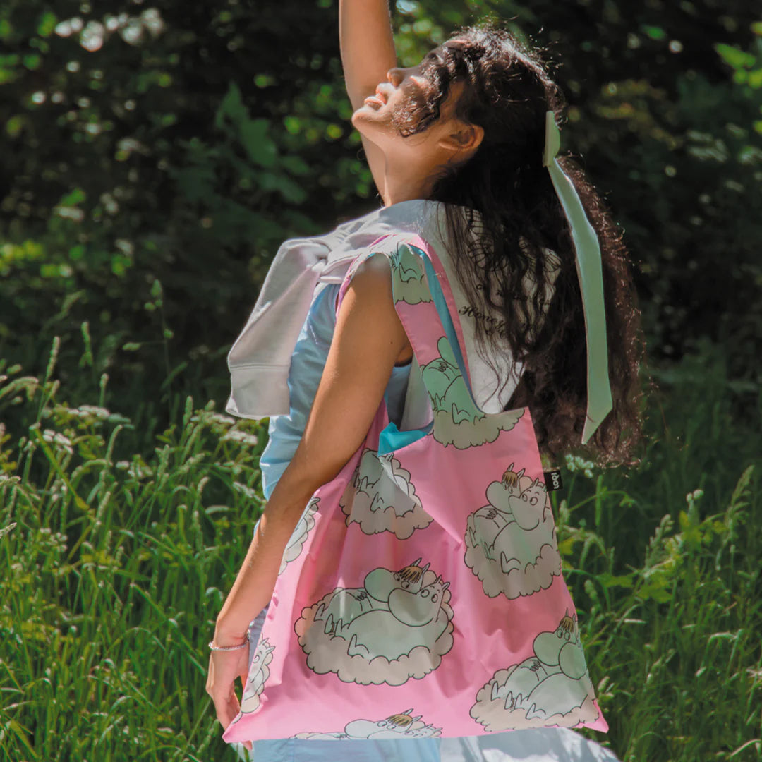 Kobieta na łonie natury z różową torbą ekologiczną Moomin LOQI z nadrukiem postaci Muminków