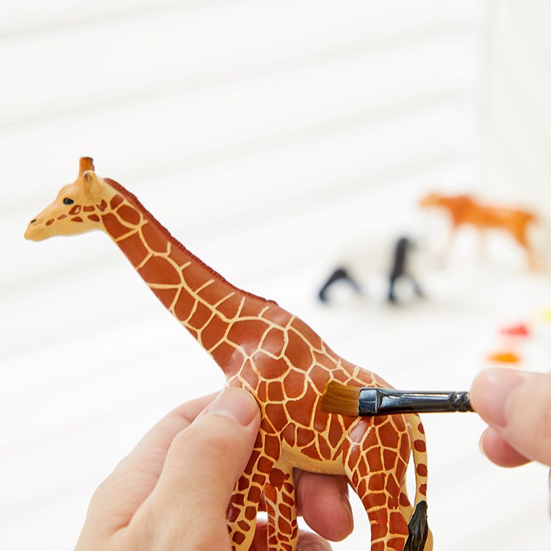 Zestaw figurek dzikich zwierząt dla dzieci z żyrafą do malowania trzymaną w dłoni