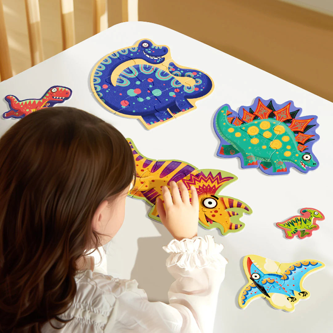 Dziecko układa kolorowe pierwsze puzzle dinozaury z dużymi elementami na białym stole