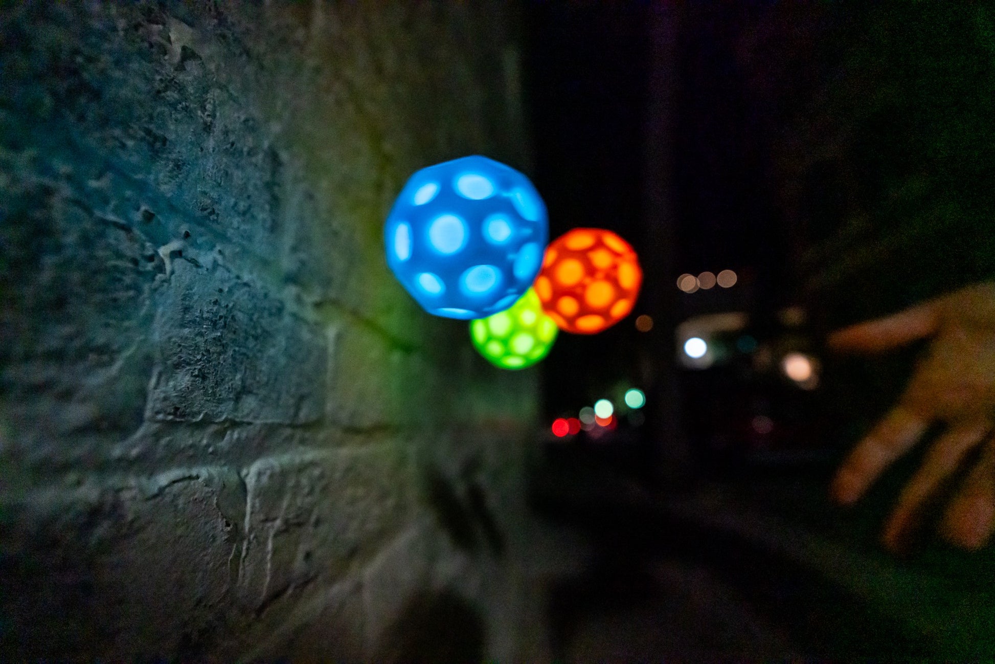 Niebieska piłeczka Waboba Moonshine niebieska świecąca podczas nocnej gry na ulicy