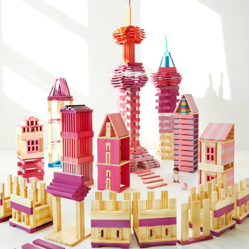Kolorowe drewniane klocki Archimedes tworzące miniaturowe budynki i wieże na białym tle