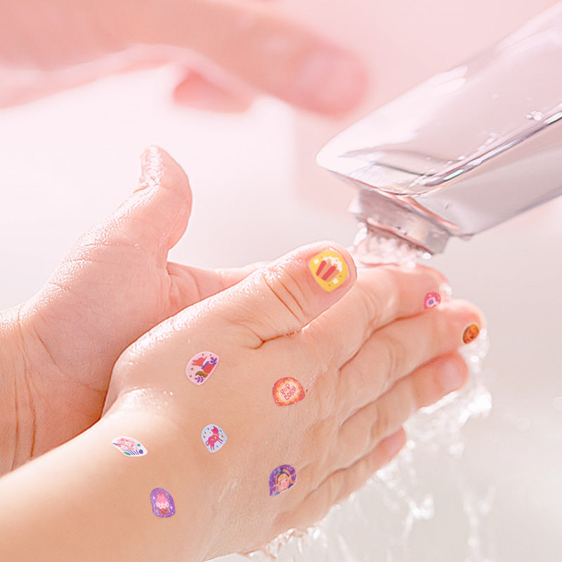 Dziecięce dłonie z kolorowymi naklejkami na paznokcie dla dzieci pod bieżącą wodą