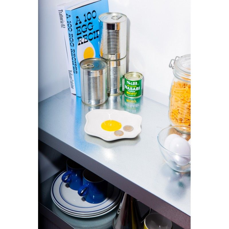 Tacka na drobiazgi jajko DOIY na kuchennym blacie obok puszek i książki kucharskiej