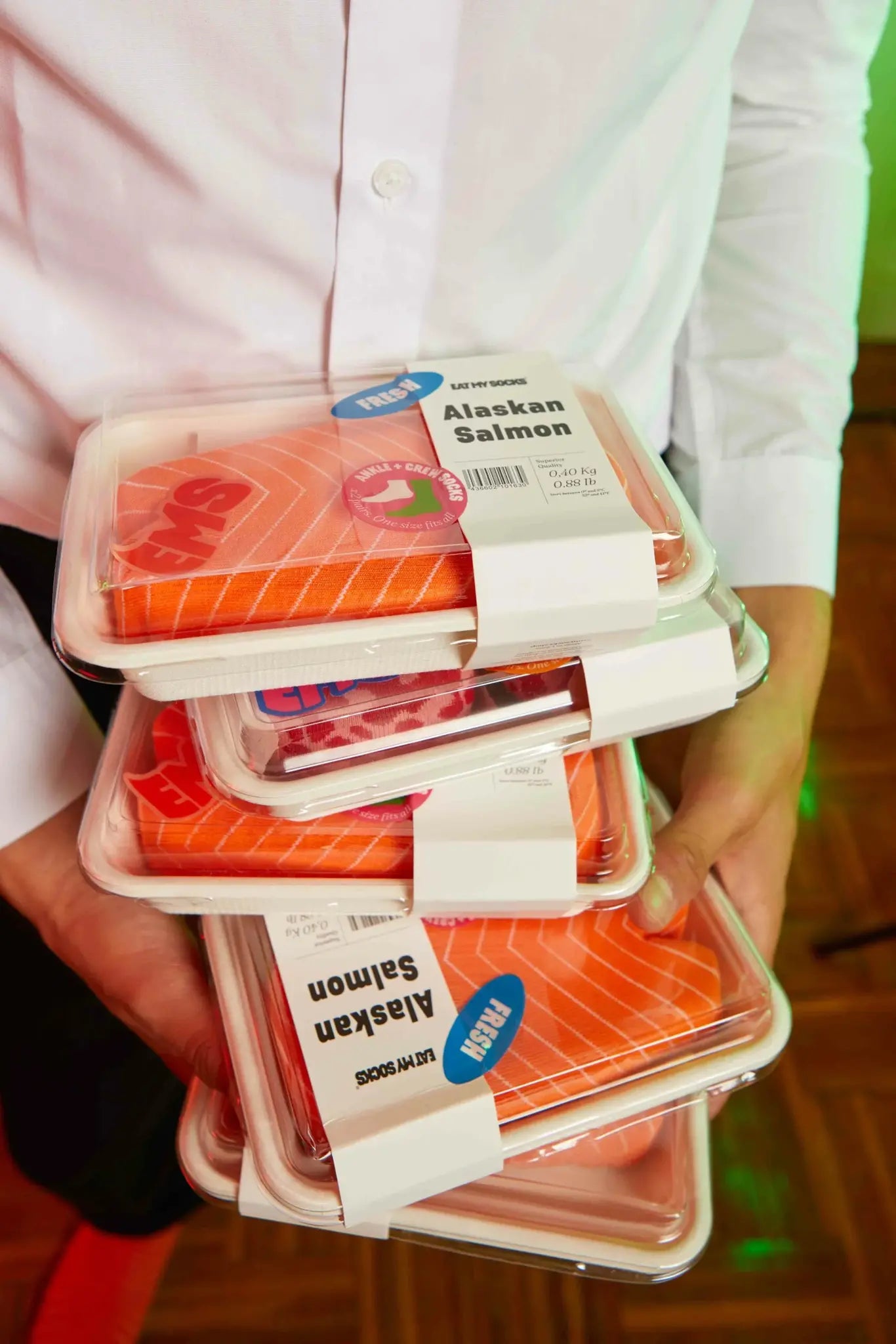 opakowania skarpetki łosoś Eat My Socks w stylu surowego łososia trzymane w dłoniach
