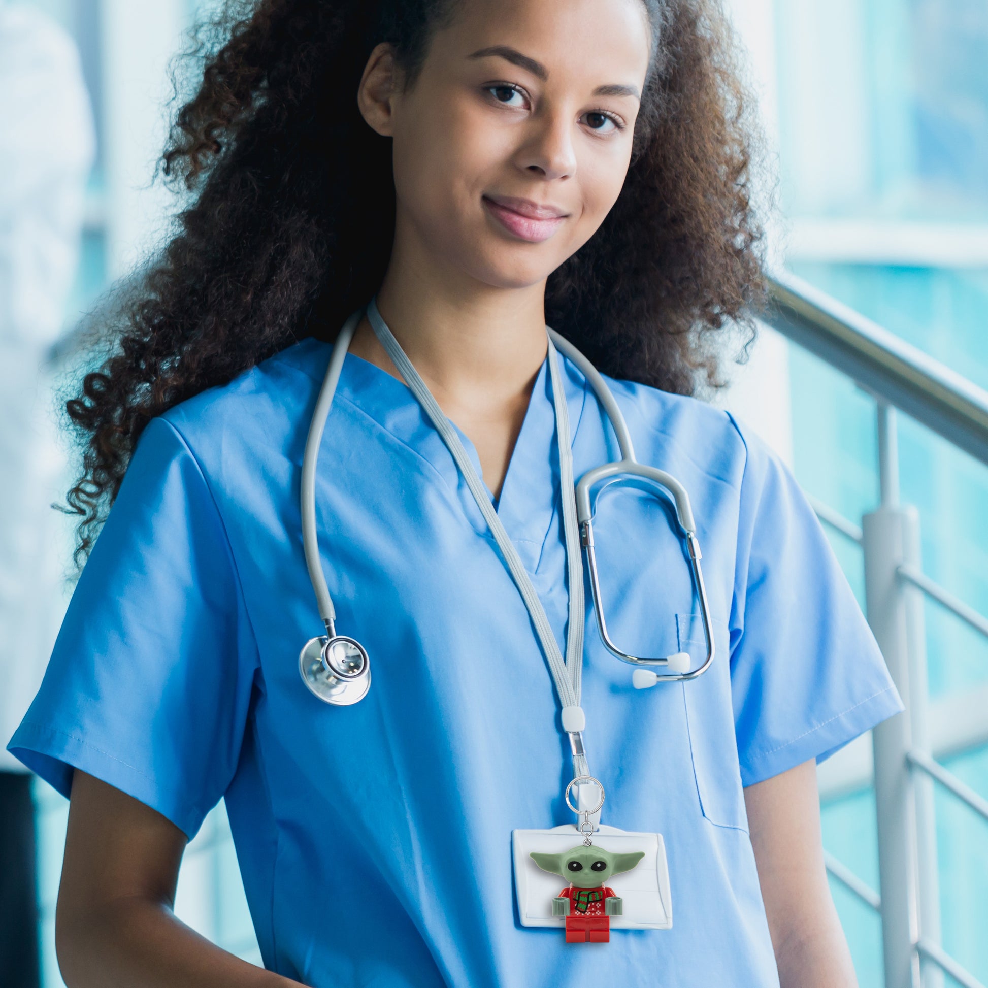 Brelok LEGO Star Wars Grogu przypięty do plakietki na smyczy u osoby w niebieskim uniformie medycznym