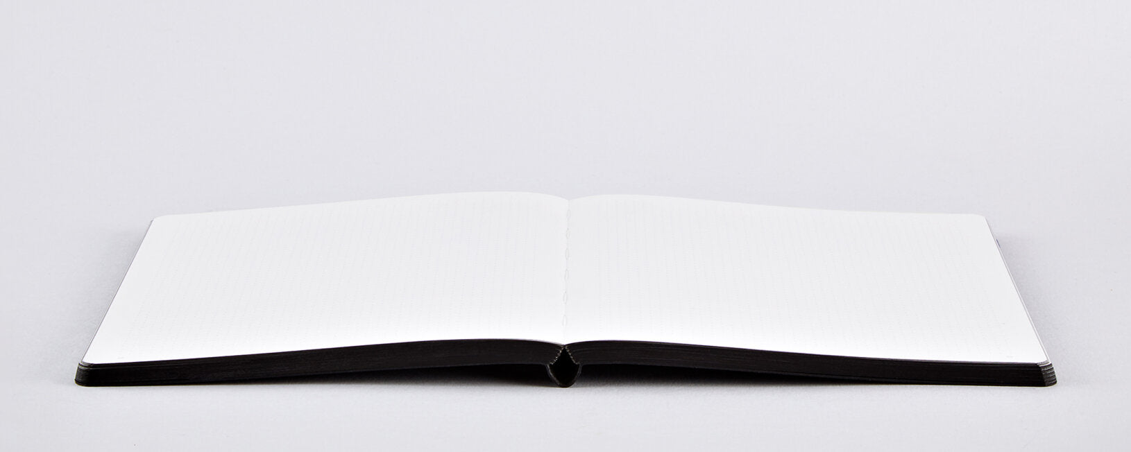 Otwarty notatnik artystyczny czarno-biały z pustymi białymi stronami do szkicowania i zapisków