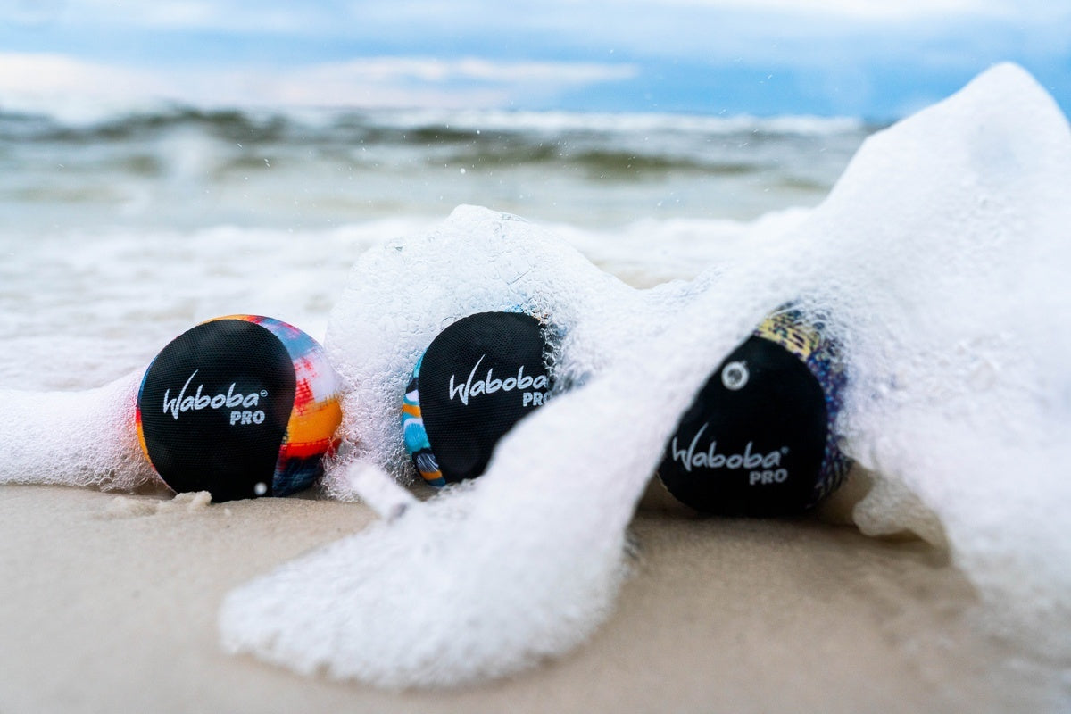 Piłeczka Waboba Pro do odbijania na wodzie na plaży przykryta pianą morską