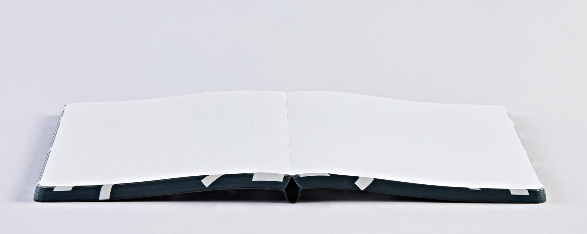 Notatnik graficzny ping pong otwarty na białych pustych kartkach firmy BV JACOB COMPANY