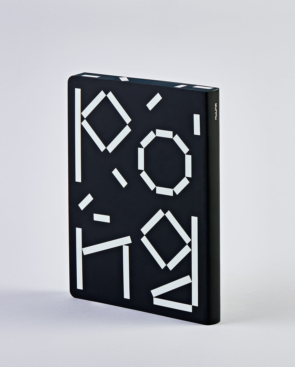 Czarny notatnik graficzny ping pong z białymi geometrycznymi wzorami na okładce