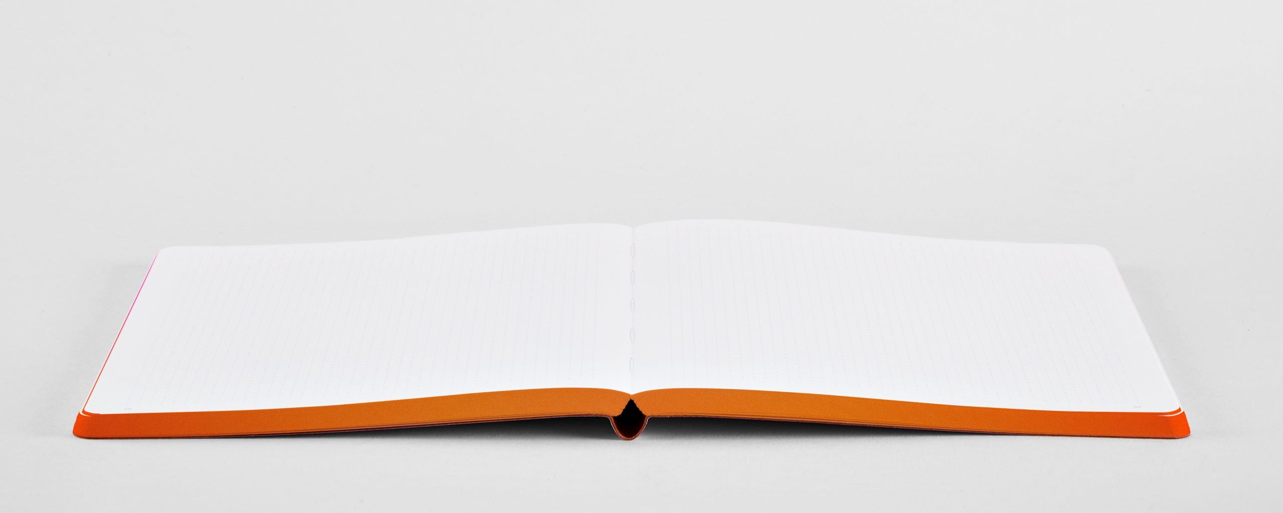 Otwarty notatnik kolorowy A5 z pustymi białymi stronami i pomarańczową oprawą