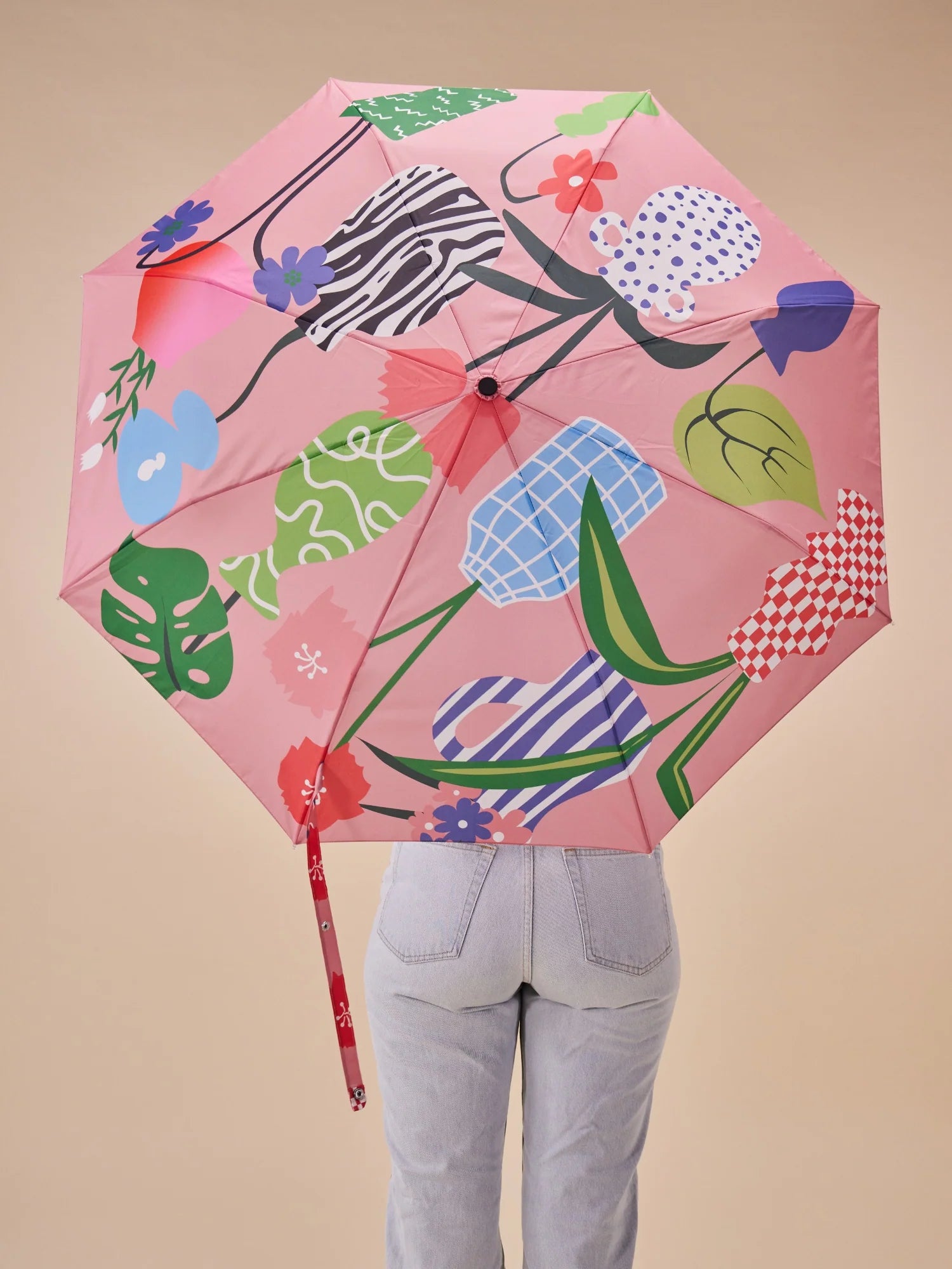 Kolorowa parasolka z uchwytem w kształcie kaczki z motywem kwiatowym na różowym tle