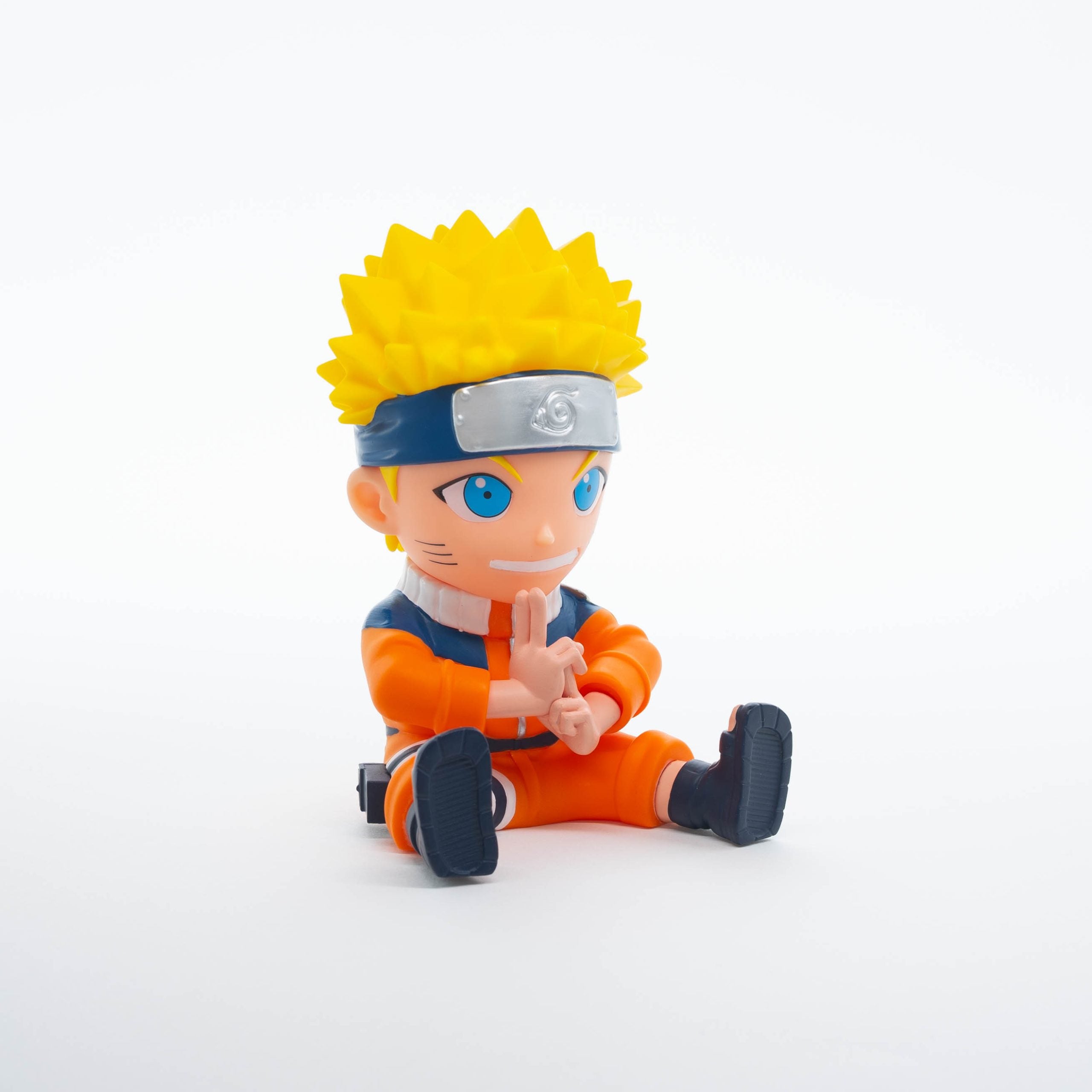 Plastoy skarbonka Naruto w pozycji siedzącej z żółtymi włosami i pomarańczowym strojem