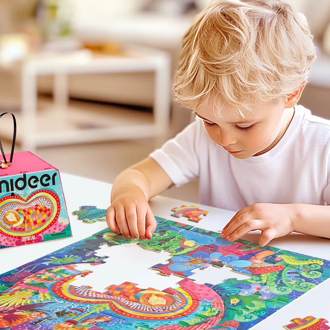 Dziecko układa puzzle artystyczne Calineczka marki mideer na stole w jasnym pokoju