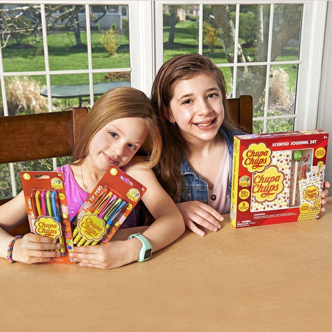 Dwie dziewczynki z flamastrami zapachowymi Chupa Chups i zestawem zapachowego notesu Chupa Chups