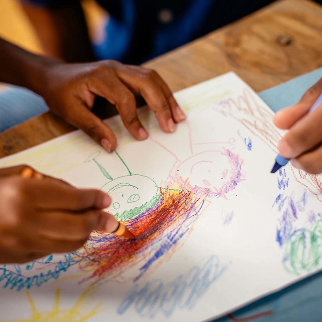 Dzieci rysujące kredkami świecowymi na kartce papieru kredki świecowe Crayola 8 sztuk