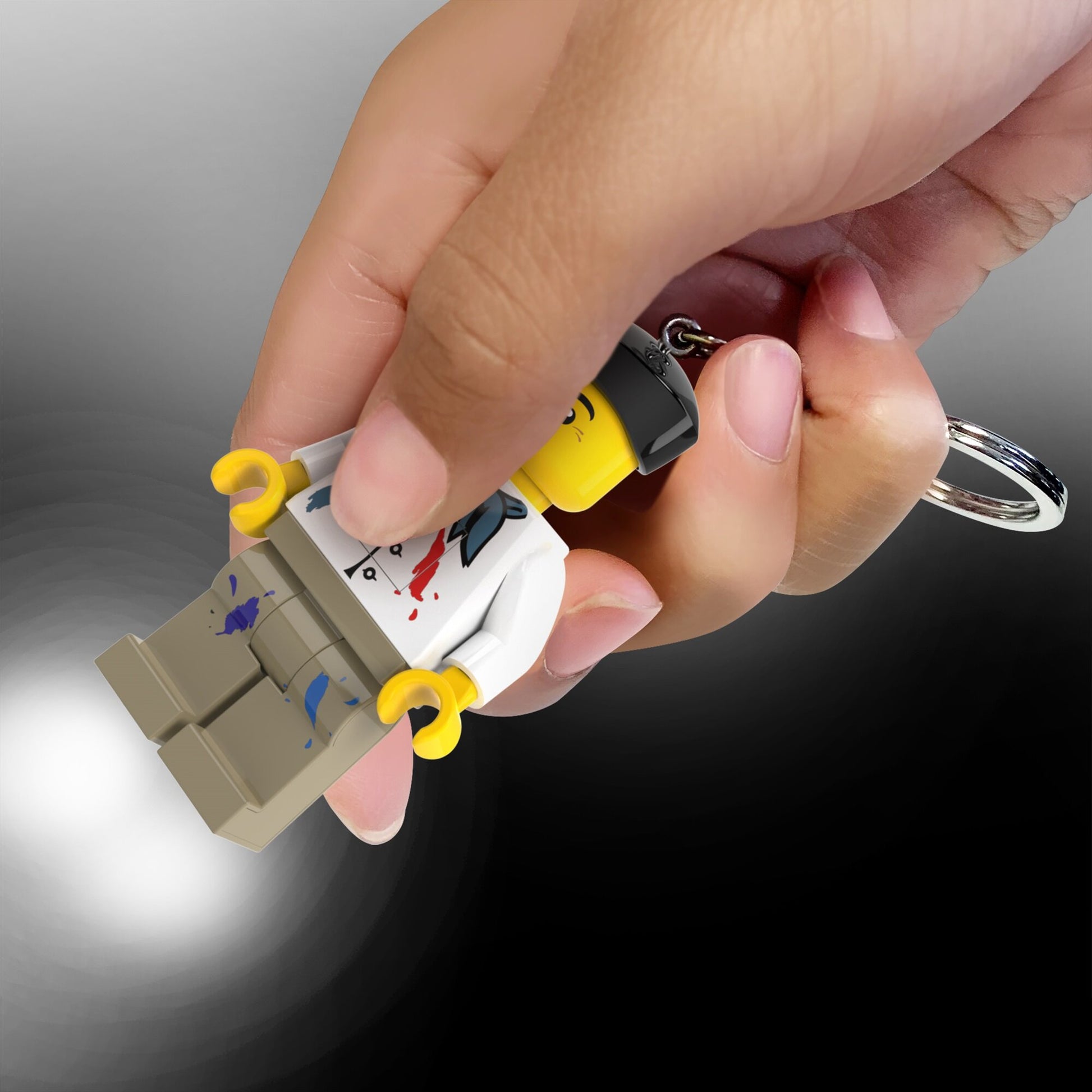 MOB brelok LEGO z latarką w kształcie figury LEGO trzymany w dłoni z włączonym światłem