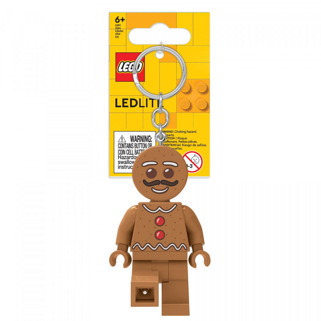 brelok LEGO piernikowy ludek z uśmiechniętą twarzą i czerwonymi guzikami na tle żółtego opakowania