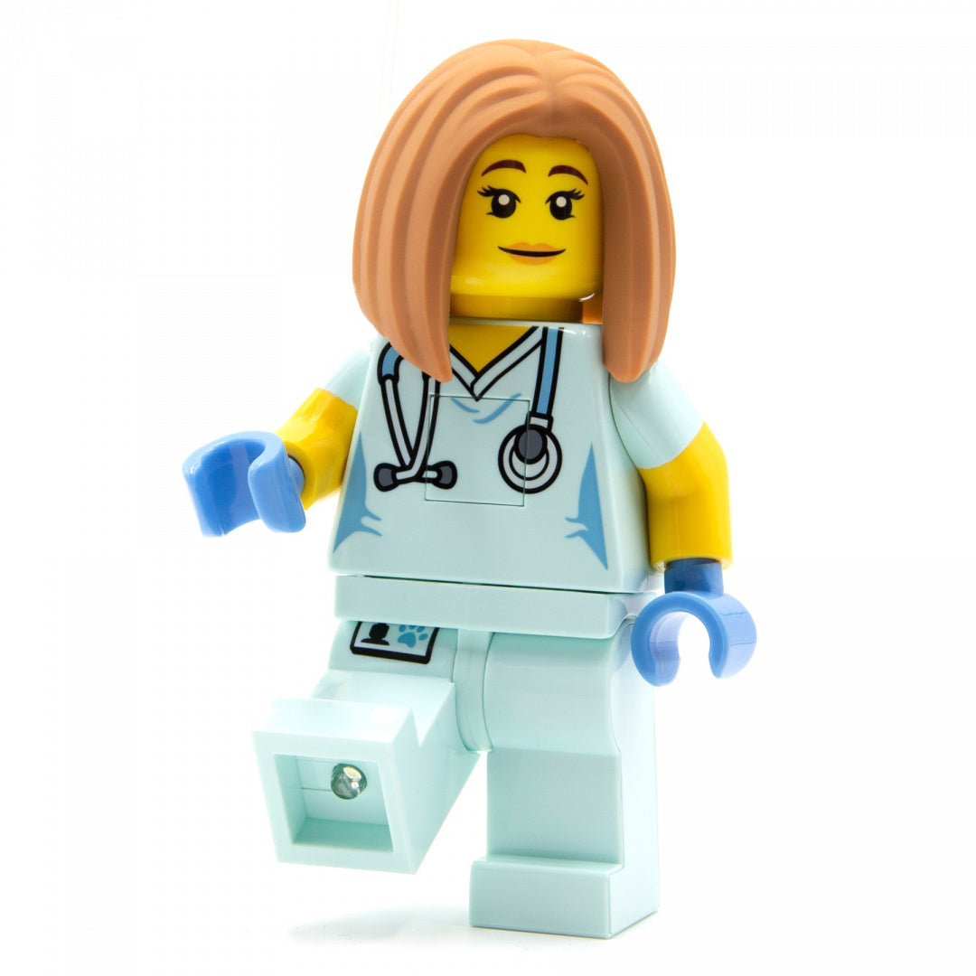 Figurka LEGO weterynarka z latarką w nodze na biały tle latarka LEGO weterynarka