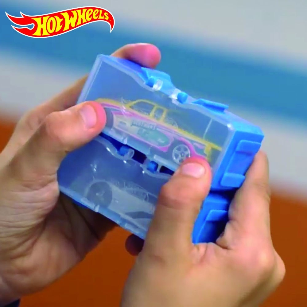Modułowa walizka Hot Wheels w niebieskim kolorze z modelem samochodu trzymana w rękach