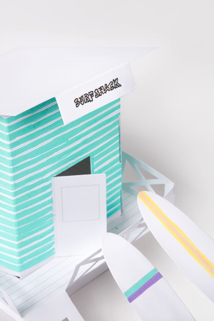 papierowy model do składania Malibu przedstawiający domek Surf Shack z dwoma papierowymi deskami surfingowymi