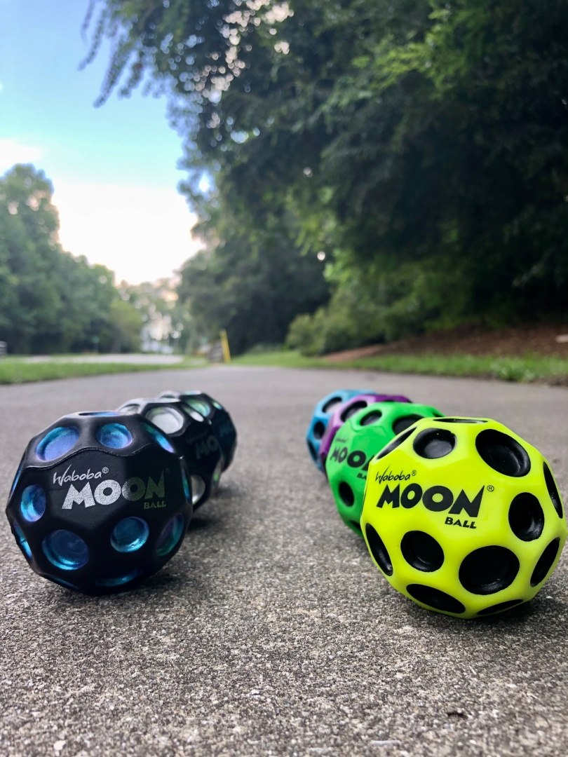 Kolorowe piłeczki Moon Ball Waboba do zabawy na zewnątrz na chodniku w parku