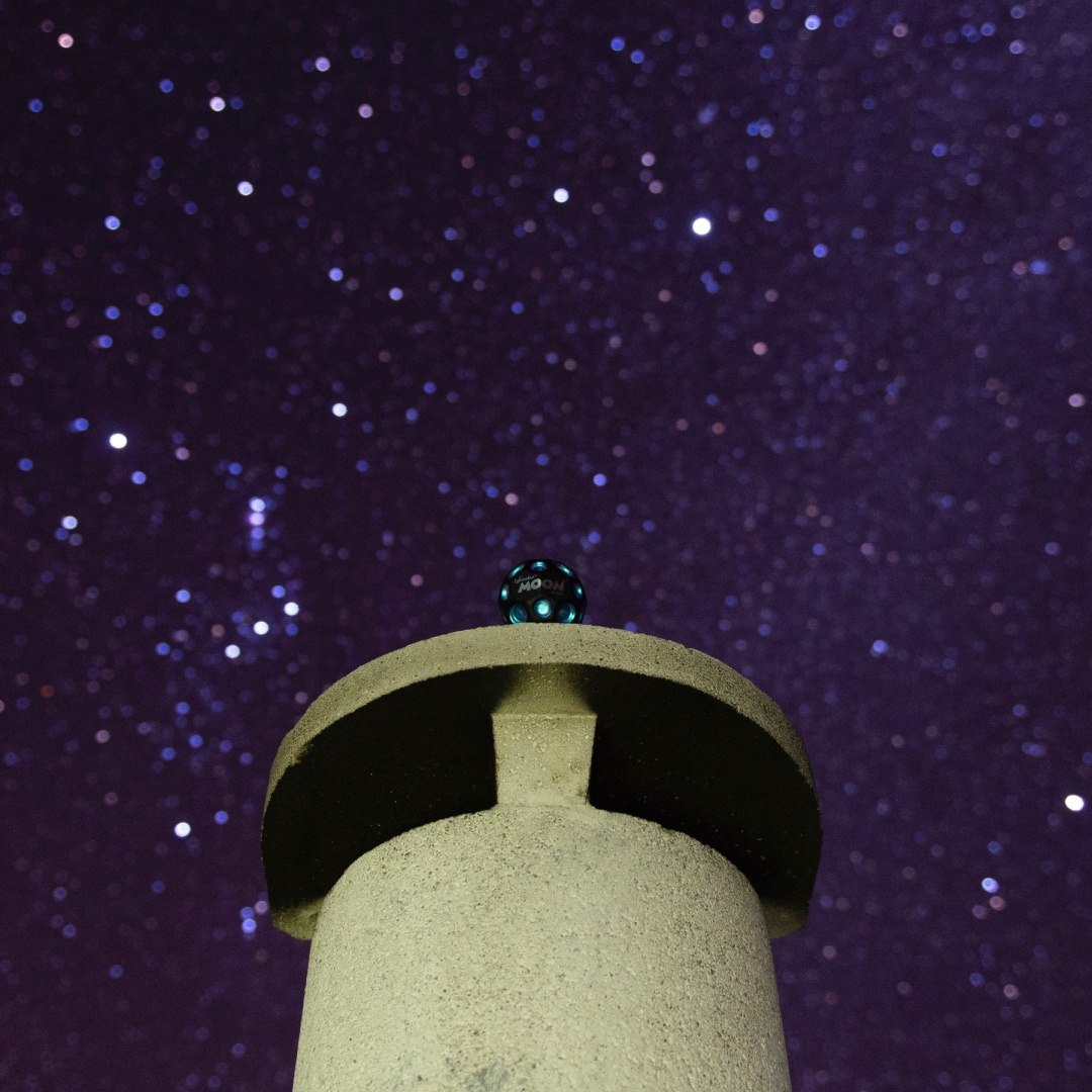 Piłeczka Moon Ball Waboba na szczycie betonowej konstrukcji na tle gwiaździstego nieba