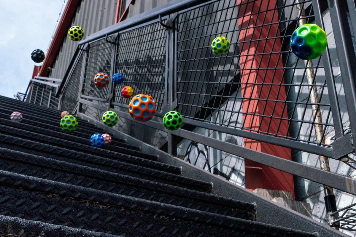 Kolorowe piłeczki Moon Ball Waboba skaczące po schodach w miejskim otoczeniu