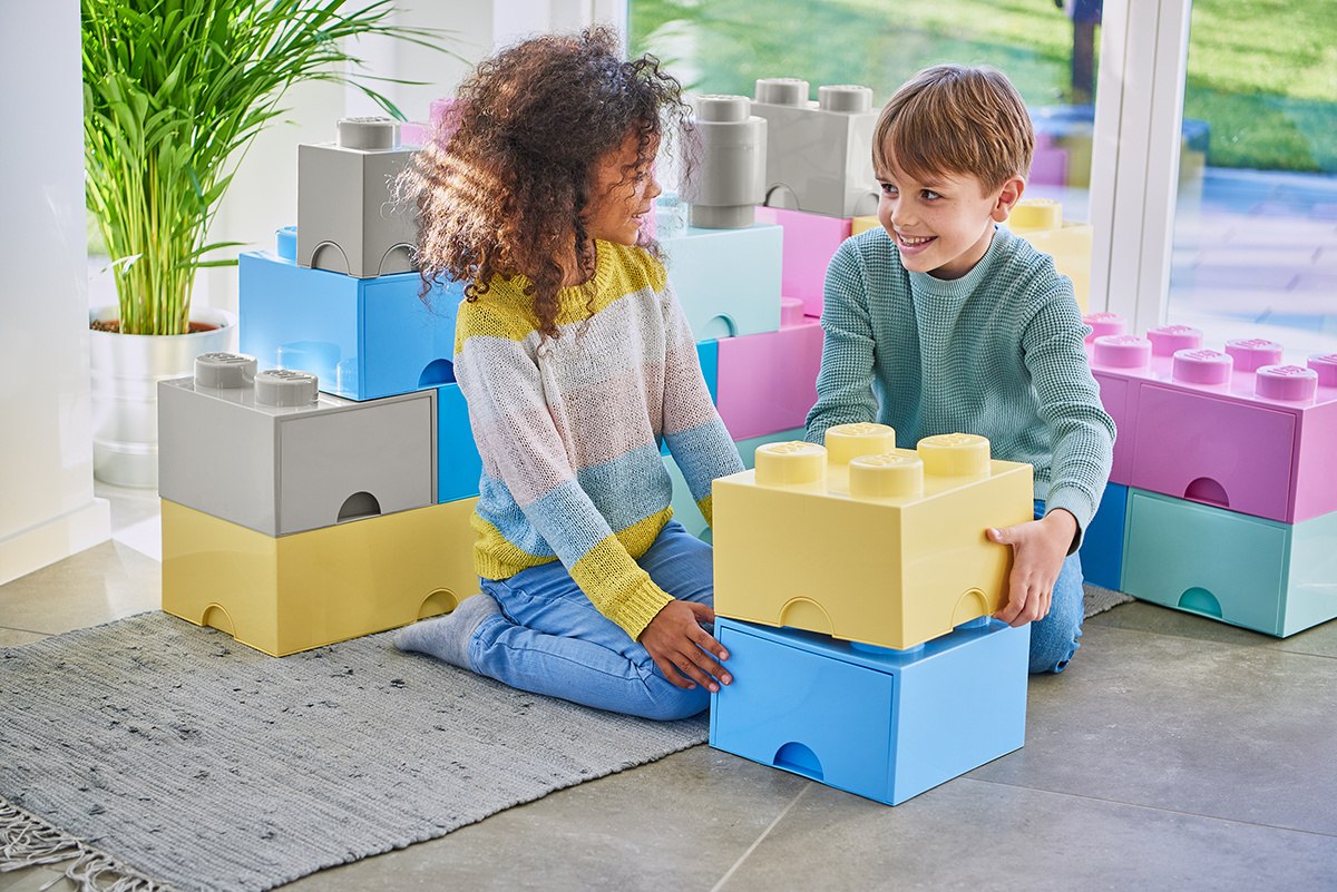 Dzieci bawiące się z kolorowym pojemnikiem LEGO na klocki w kształcie dużych klocków konstrukcyjnych