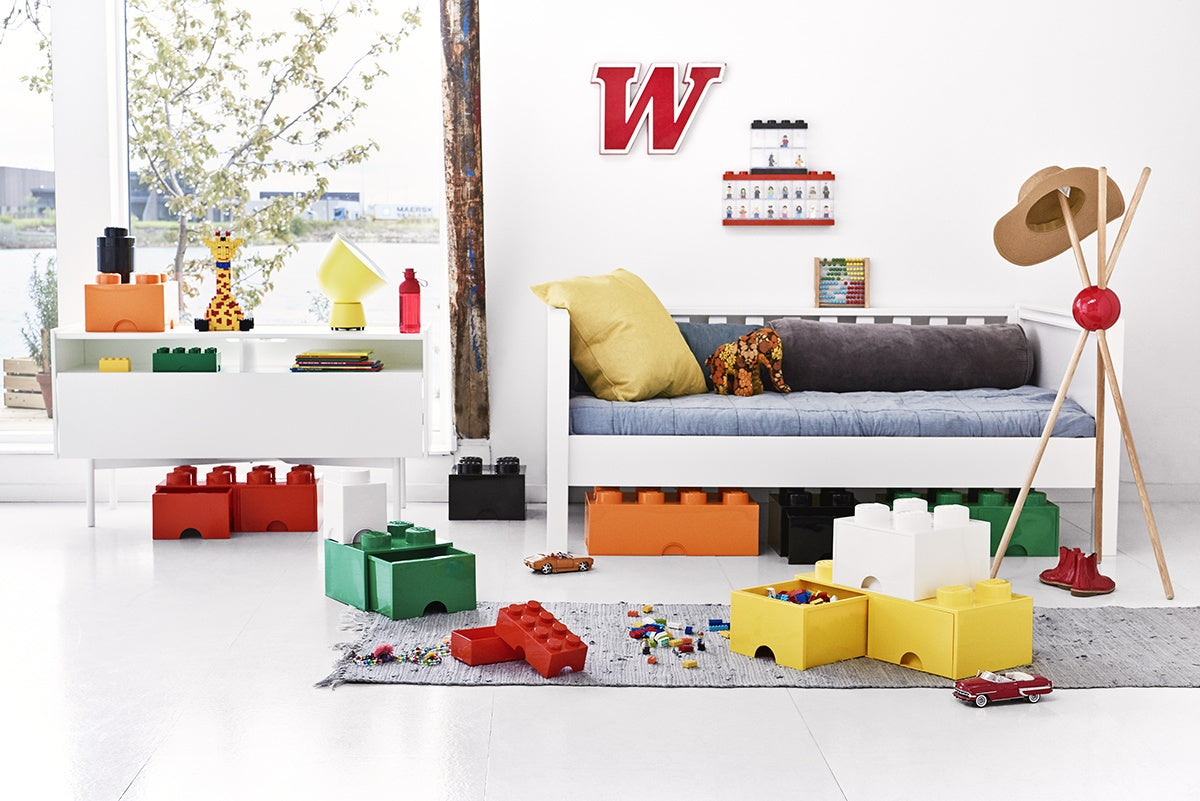 Kolorowy pojemnik LEGO na zabawki w formie klocków w pokoju dziecięcym z kanapą i dywanikiem
