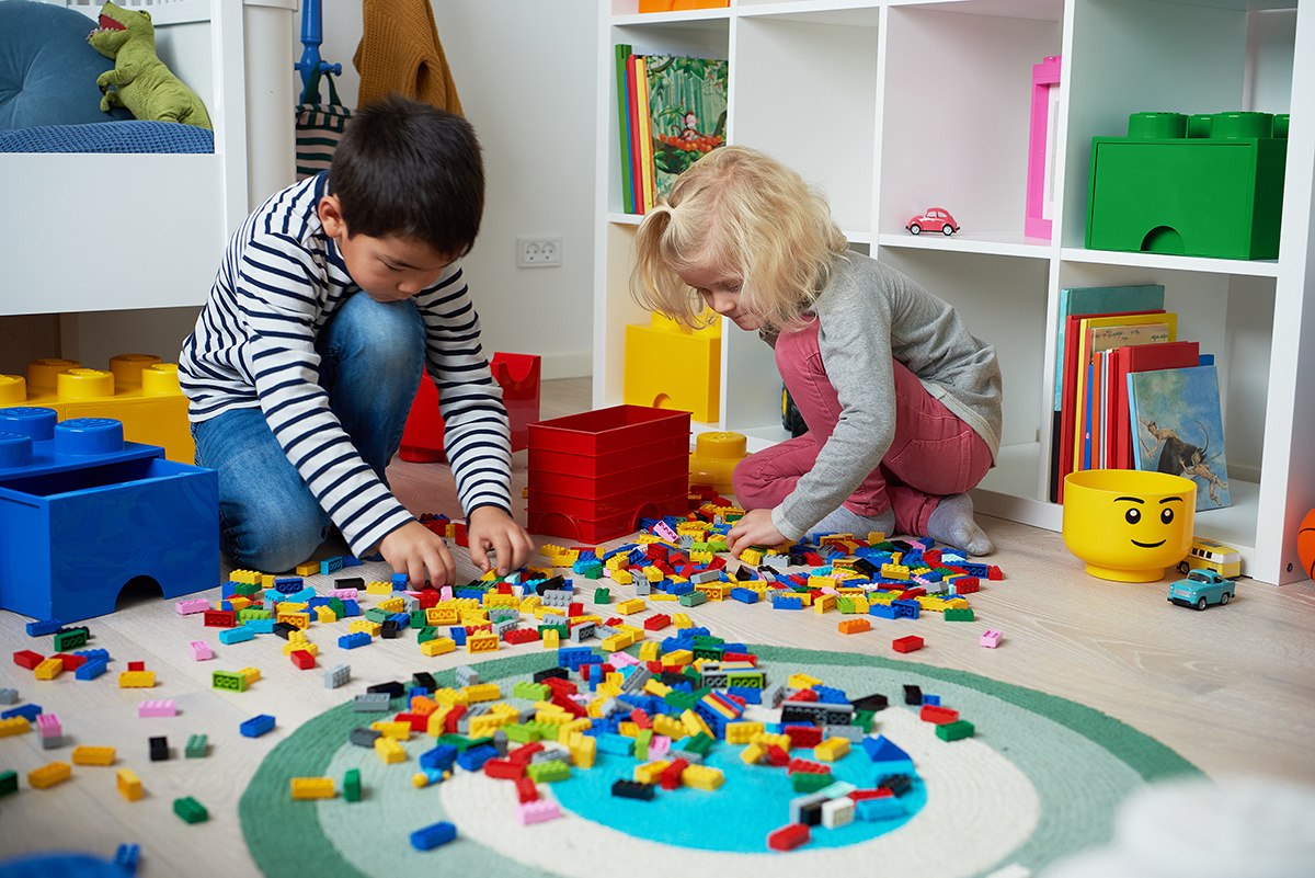 Dzieci bawiące się kolorowymi klockami z pojemnika LEGO Brick 4 niebieski w jasnym pokoju zabaw