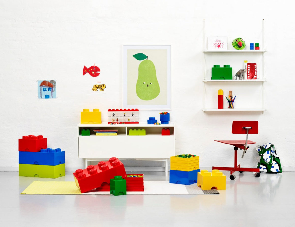 Pojemnik LEGO Brick 4 niebieski w kolorze niebieskim wśród innych kolorowych pojemników na klocki LEGO w jasnym pokoju dziecięcym