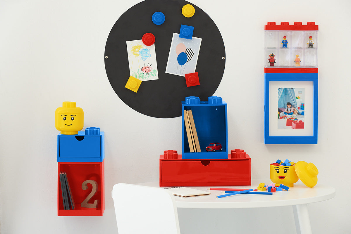 czerwona półka LEGO Brick 4 zamontowana na ścianie z dodatkowymi niebieskimi i żółtymi pudełkami LEGO