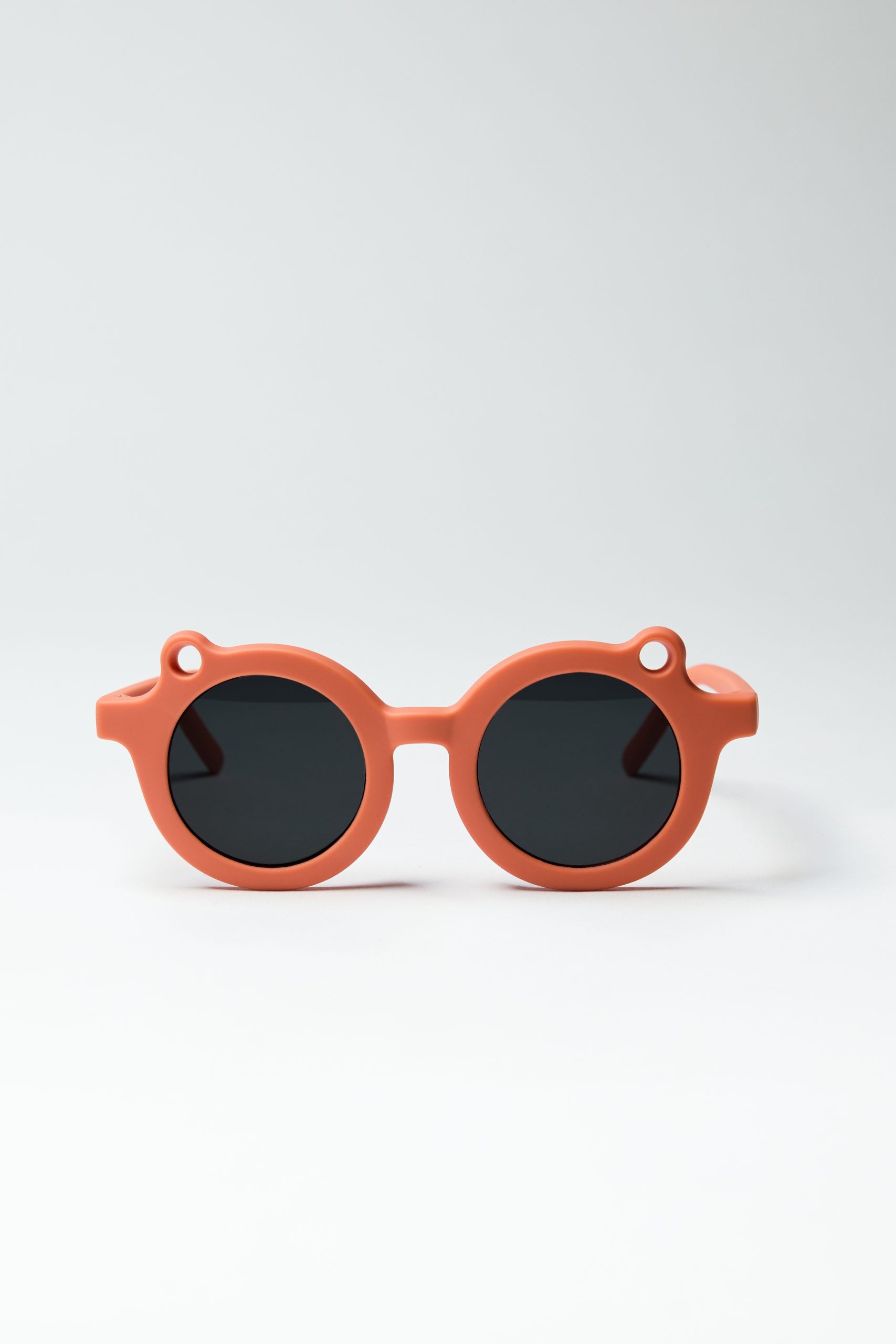 Pomarańczowe okulary przeciwsłoneczne dla dzieci z okrągłymi czarnymi szkłami