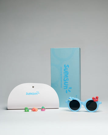 Gafas de sol para niños SumSun en montura azul con estuche y adornos coloridos.