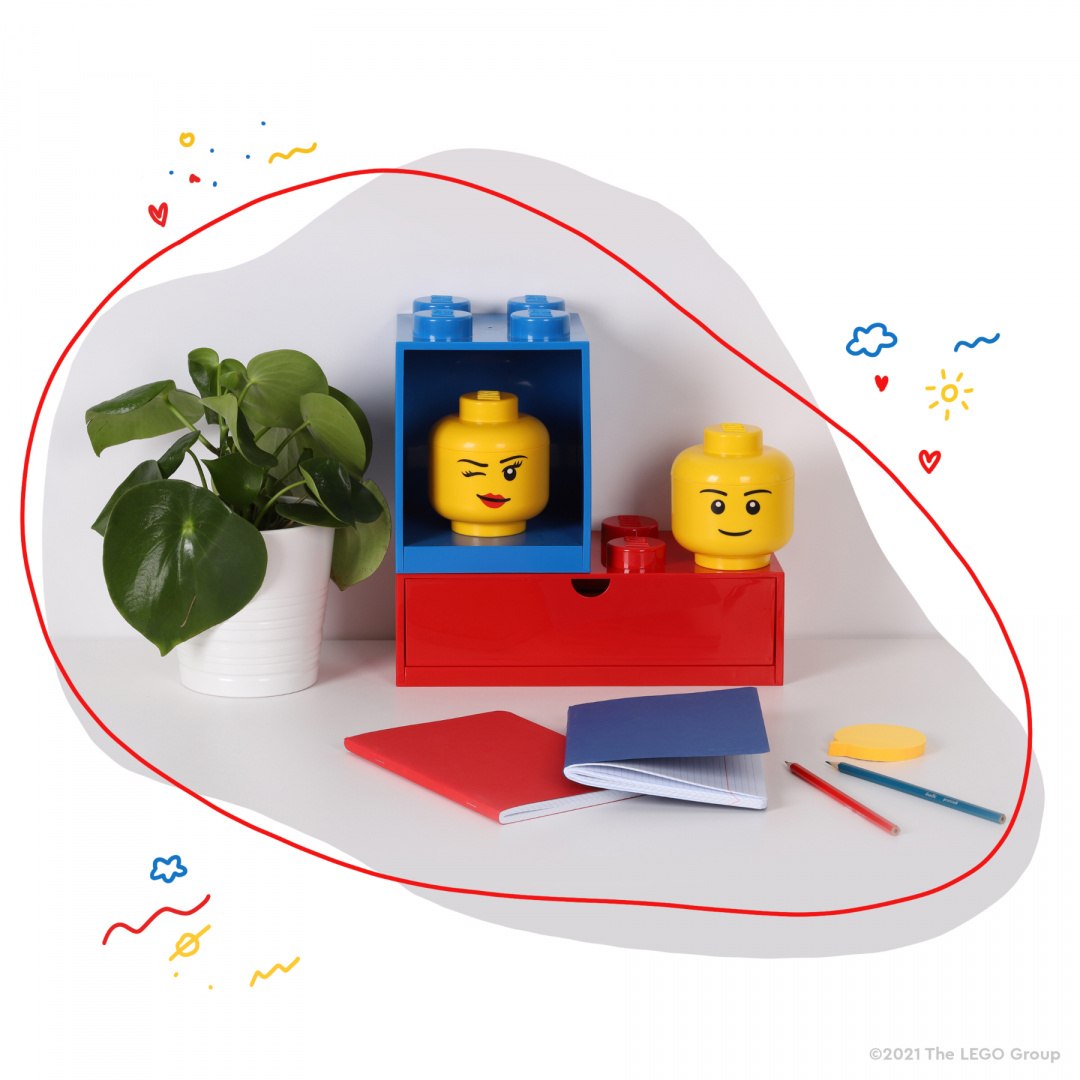 Kolorowa szufladka LEGO na biurko z klockami i głowami LEGO obok rośliny i przyborów szkolnych